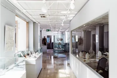 Ein helles Museum mit Ausstellungsstücken in Vitrinen. Der Flur ist modern gestaltet und lässt viel Licht herein.