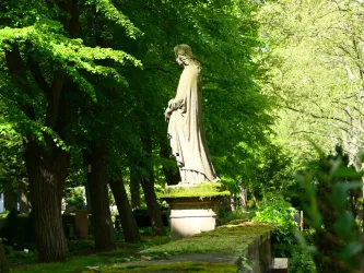 Eine Statue in einem ruhigen Park, umgeben von hohen Bäumen. Das Licht fällt sanft durch das Blätterdach und schafft eine friedliche Atmosphäre.