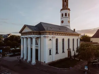 Eine elegante Kirche mit weißen Säulen und einem Turm. Die Architektur ist klassisch und ansprechend.