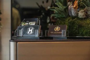 Ein Empfangstresen mit verschiedenen Visitenkarten. Im Hintergrund sind dekorative Pflanzen und eine ansprechende Gestaltung zu sehen.