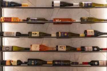 Eine elegante Weinregal mit mehreren Flaschen in verschiedenen Farben. Die Flaschen sind ordentlich angeordnet und präsentieren eine Vielzahl von Etiketten.