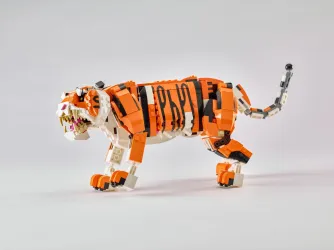 Ein LEGO-Tiger läuft stolz über den Boden. Er ist orange mit schwarzen Streifen und sieht sehr detailreich aus.