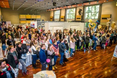 Eine große Menschenmenge in einem Ausstellungsraum mit Ständen. Die Besucher scheinen an den angebotenen Produkten interessiert zu sein.