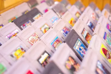 Eine Ansammlung von Spielkassetten in verschiedenen Farben und Designs. Die Kassetten sind ordentlich in einem Regal angeordnet.