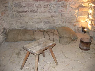 Verließ mit Holzstuhl und Eimer