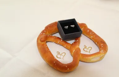 Eine Brezel mit einem Paar Ohrringe in Brezelform und zwei Brezelförmigen Anhängern