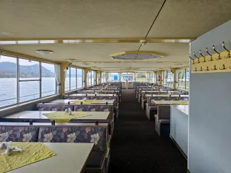 Der Innenraum eines Ausflugsschiff mit Sitzbänken und Tischen