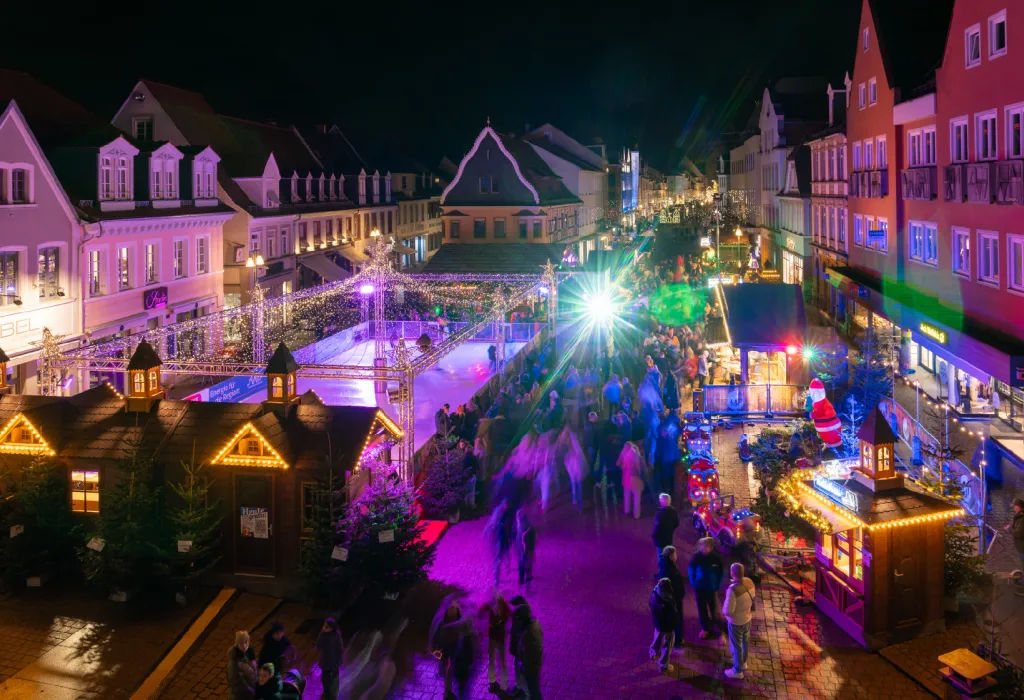 Ein stimmungsvoll beleuchteter Weihnachtsmarkt in den Abendstunden