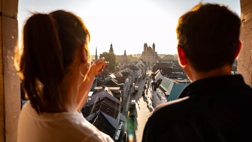 Zwei Personen genießen die Aussicht auf die Stadt Speyer mit dem Dom bei Sonnenaufgang