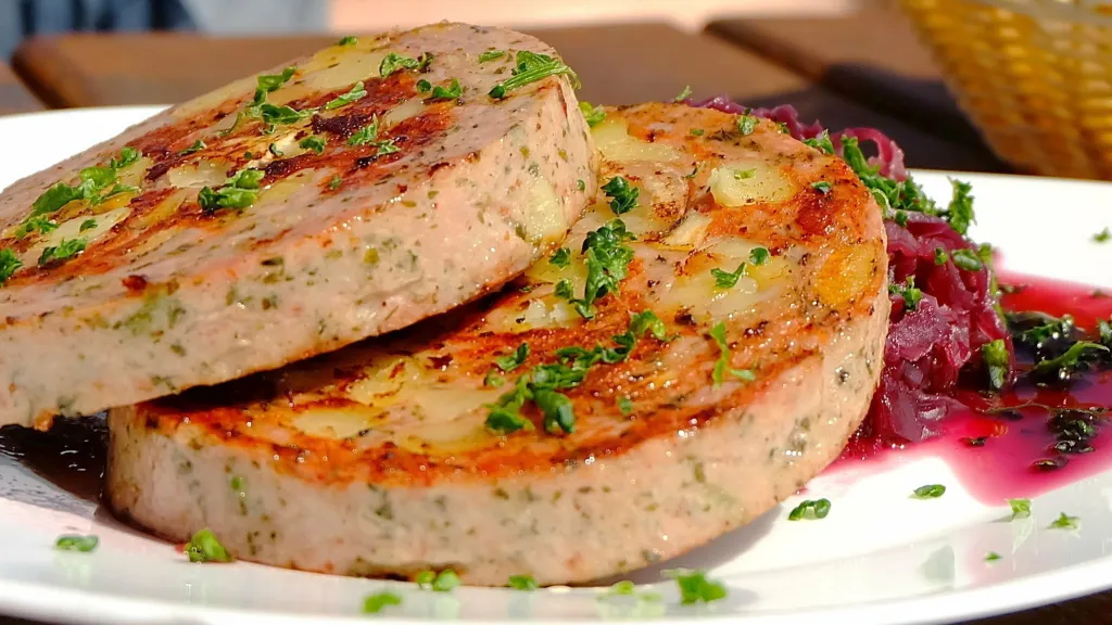Zwei Scheiben Pfälzer Saumagen auf einem Teller mit Rotkraut