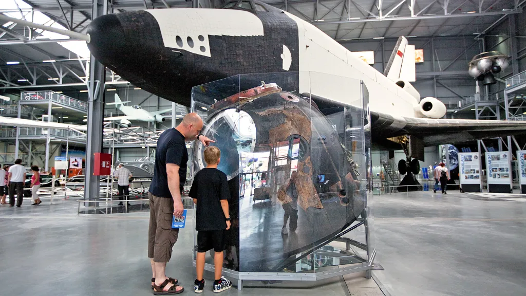 Ein Mann und ein Junge stehen vor einem Museumsobjekt im Technik Museum Speyer