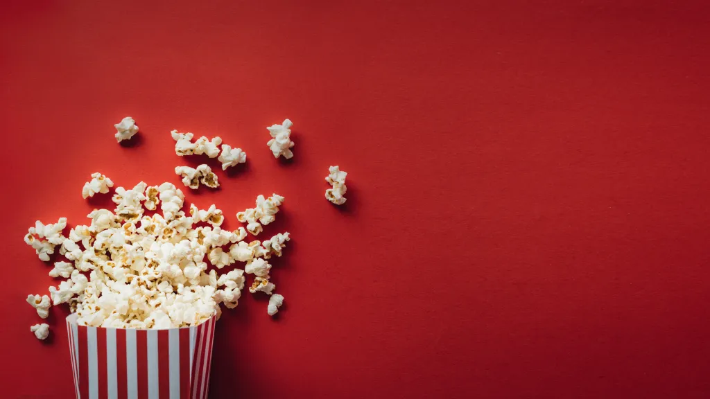 Packung frisches Popcorn auf rotem Hintergrund