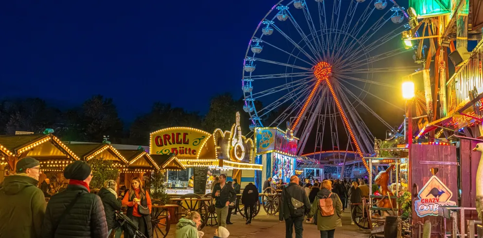 Herbstmesse in Speyer bei blauer Stunde mit leuchtenden Buden und einem Riesenrad