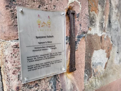 Hinweisschild an Steinmauer mit der Aufschrift "Speyerer Schuh"