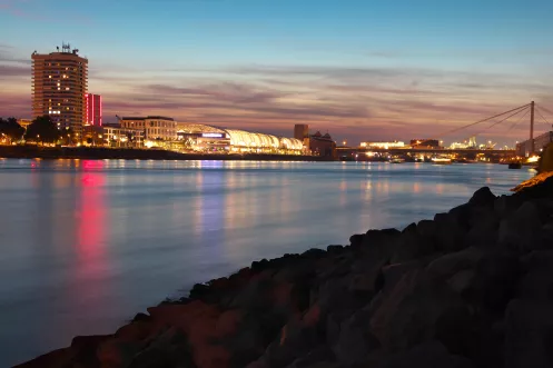 Abenddämmerung am Rheinufer mit Blick auf die Stadt Ludwigshafen in stimmungsvoller Beleuchtung