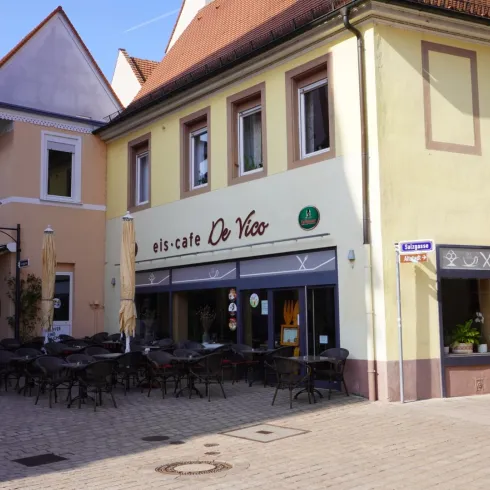 Ein gemütliches Eiscafé mit Terrassenplätzen. Die Fassade ist hellgelb und lädt zum Verweilen ein.