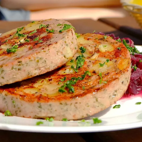 Zwei Scheiben Pfälzer Saumagen auf einem Teller mit Rotkraut