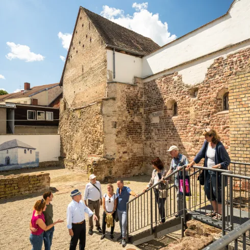 Personengruppe inmitten von Mauerüberresten